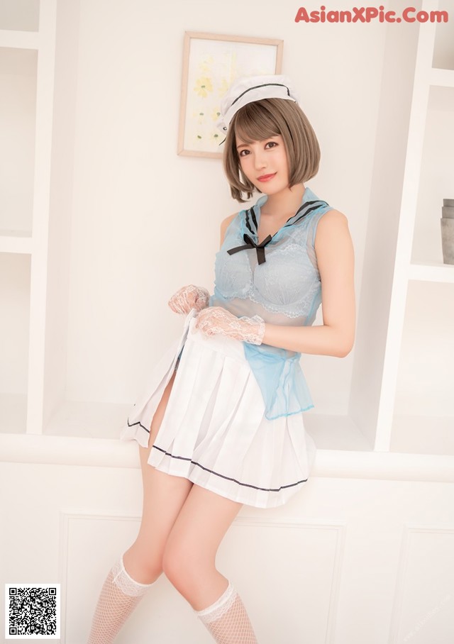 A woman in a blue and white dress posing for a picture.
