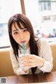 A woman sitting at a table with a glass of water.