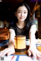 A woman sitting at a table with a lantern in front of her.