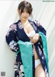 A woman in a blue and white kimono posing for a picture.