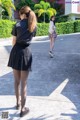 Two young women walking down a sidewalk in front of a building.