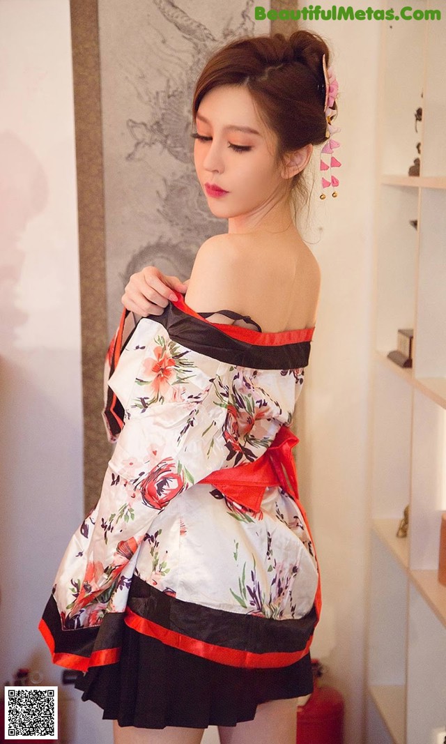 A woman in a white and red dress is posing for a picture.