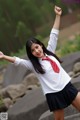 A young woman in a school uniform posing for a picture.