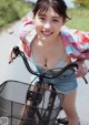 A woman riding a bike with a basket on the back.